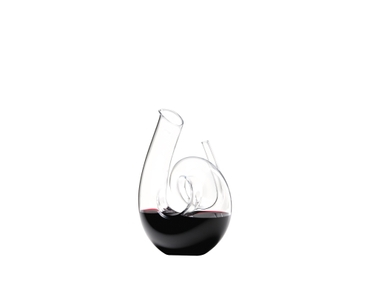 RIEDEL Curly Decanter filled with a drink on a white background