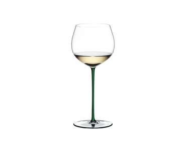 A RIEDEL Fatto A Mano Oaked Chardonnay glass in green filled with white wine on a transparent background. 