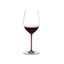A RIEDEL Fatto A Mano Cabernet/Merlot glass in red filled with red wine on a transparent background. 