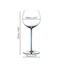 A RIEDEL Fatto A Mano Oaked Chardonnay glass in turquoise filled with white wine on a white background. 
