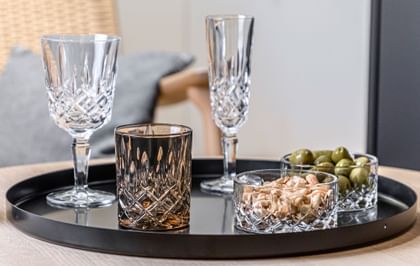 NACHTMANN Noblesse Series on a table top next to nuts and olives.