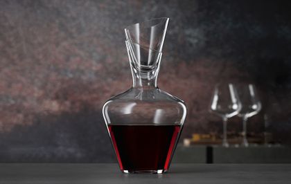 SPIEGELAU Definition Wine Carafe with Stopper filled with red wine on grey background.