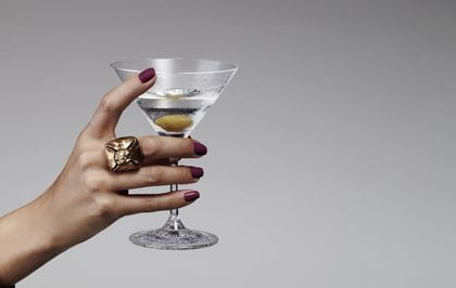 A lady's hand holding the Spiegelau Perfect Serve Cocktail glass filled with a Martini.