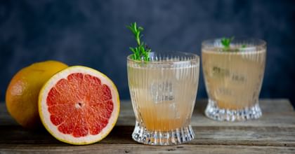 grapefruit cocktail next to grapefruits