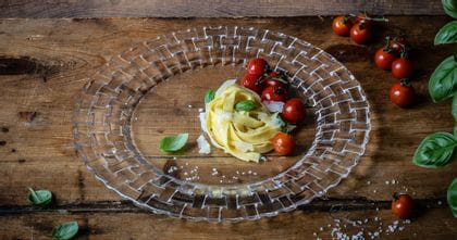 Der NACHTMANN Bossa Nova Charger-Teller mit Tagliatelle, gegrillten Tomaten, Basilikum und Parmesan darauf.<br/>
