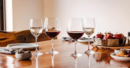 Table setting featuring the Spiegelau Vino Grande series filled with red and white wine. Food and bowls surround the glassware.
