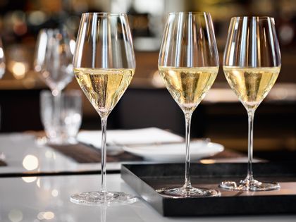 With Champagne filled SPIEGELAU Highline Champagne glasses on a serving tray on a table.<br/>
