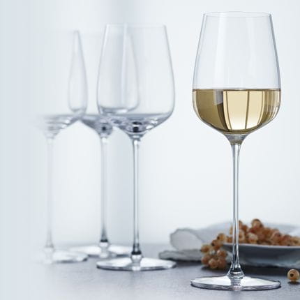 Cuatro copas SPIEGELAU Willsberger Anniversary White Wine, una de ellas llena de vino blanco.<br/>