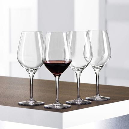 Cuatro copas de vino tinto SPIEGELAU Authentis sobre una mesa, una de ellas llena de vino tinto.<br/>