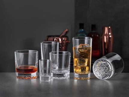 The SPIEGELAU Lounge 2.0 collection on a grey surface with some glasses filled with beverages.