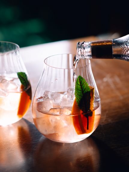 RIEDEL Gin Set Optic on a wooden table with tonic pouring into the glass.