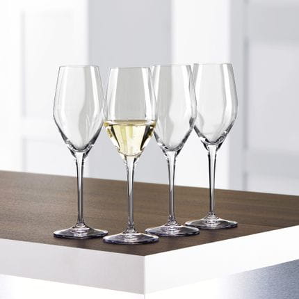 Quattro bicchieri da Champagne SPIEGELAU Authentis su un tavolo, uno dei quali è riempito di Champagne.<br/>