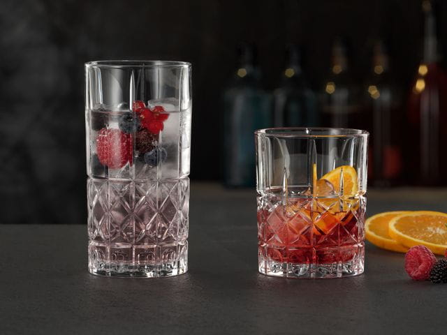 The NACHTMANN Highland Diamond longdrink glass filled with a berry cocktail on ice next to the Highland Diamond tumbler filled with a Negroni.<br/>
