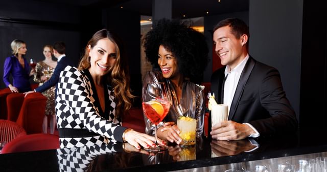 three people with several Riedel Cocktail glasses