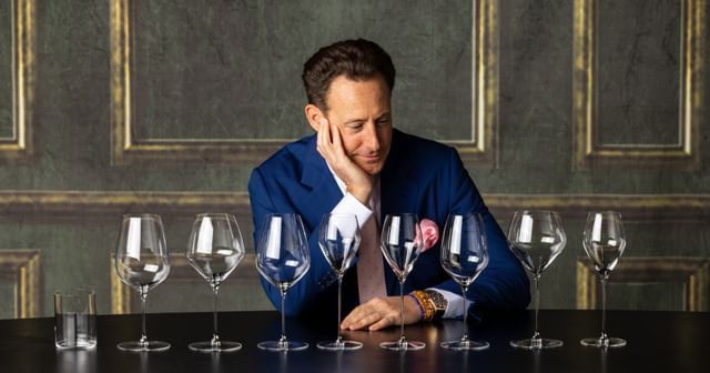Maximilian J. Riedel looking at a row of glasses
