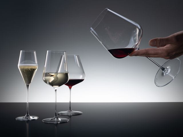 Un grupo de tres copas SPIEGELAU Definition de las cuales la copa Champagne se llena con vino espumoso, la copa Universal con vino blanco y la copa Borgoña con vino tinto.<br/>