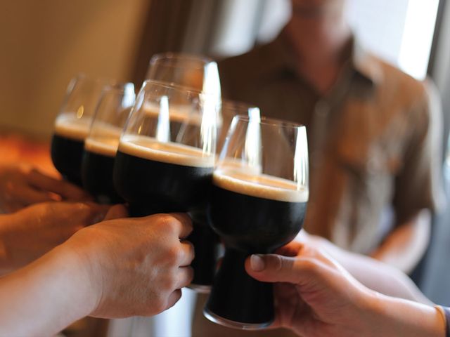People cheersing with the SPIEGELAU Craft Beer Stout glass filled with beer.